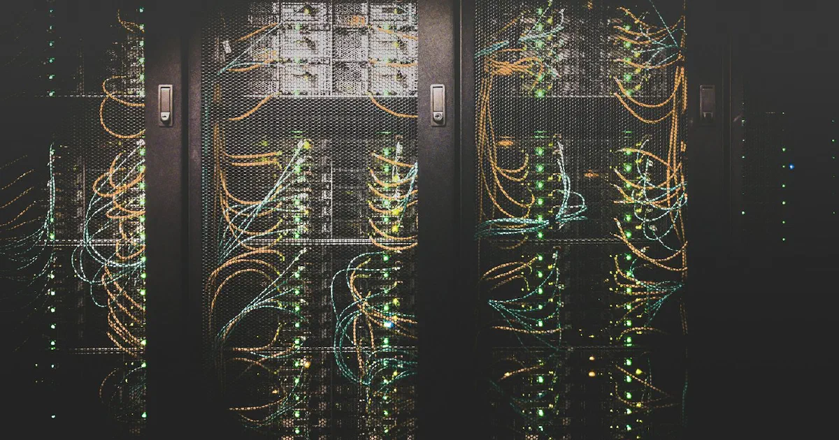 Server racks with orange and blue network cables and green status lights