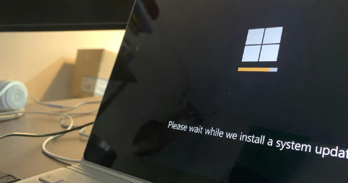 Laptop screen showing a system update in progress on a desk
