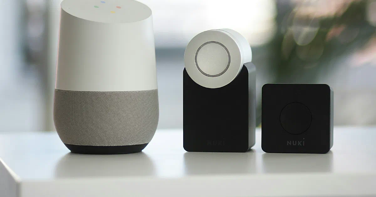 Google smart speaker next to a smart lock and bridge on a shelf