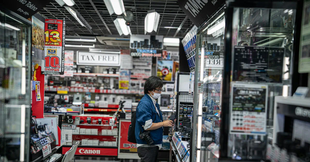 Shopper browsing shelves in a brightly lit electronics store