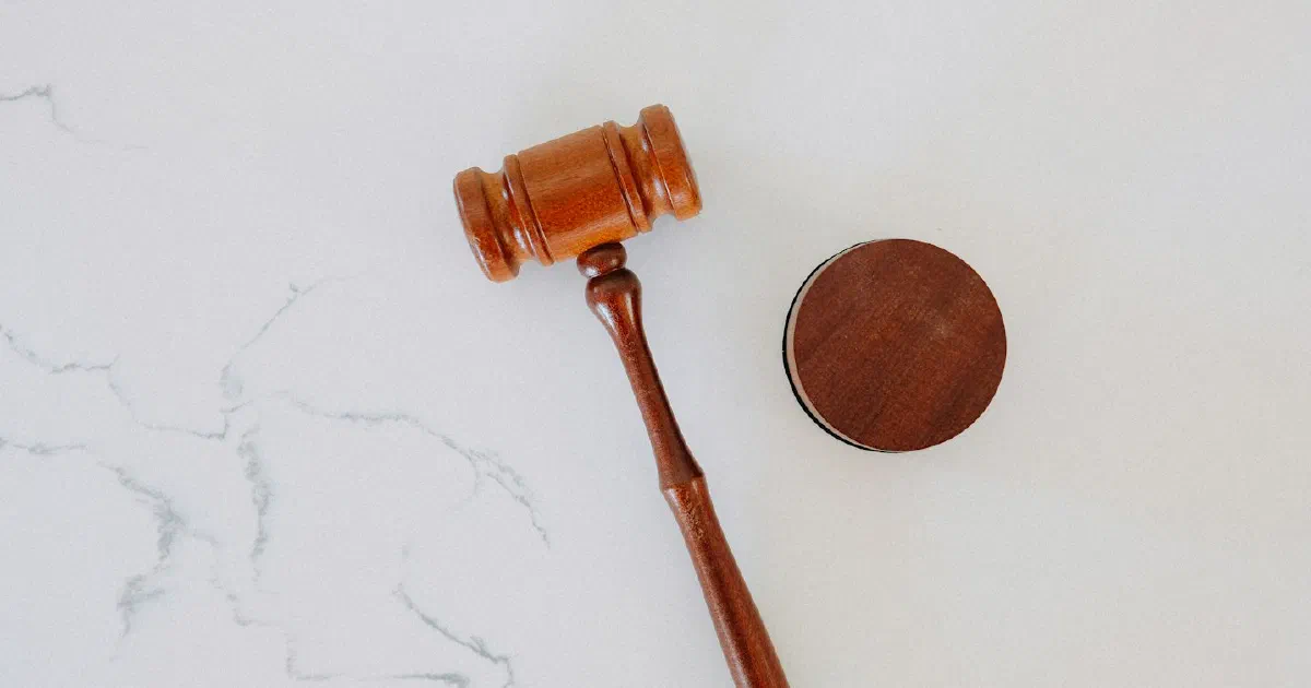 Wooden gavel and sound block on a white marble surface