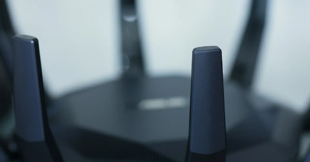 Close-up of a black Wi-Fi router with several tall antennas